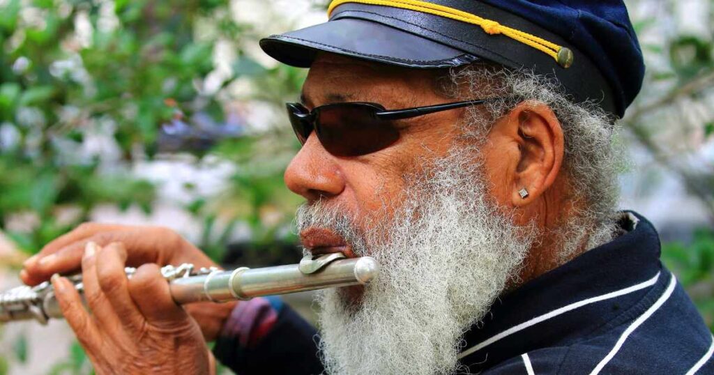 An adult man playing the flute